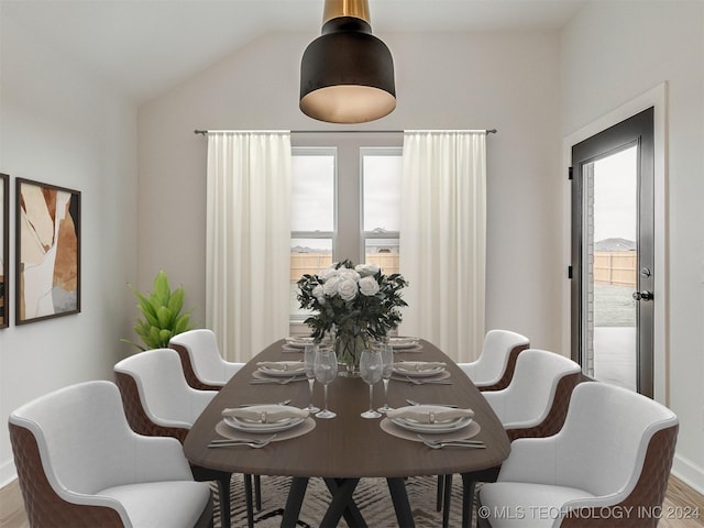 dining area featuring wood-type flooring and vaulted ceiling