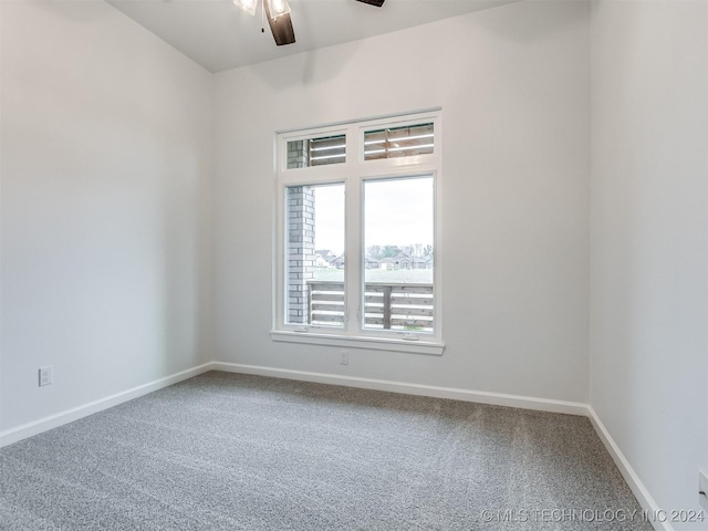 carpeted spare room featuring ceiling fan