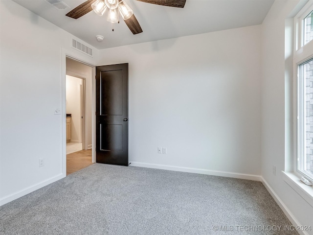 carpeted empty room featuring ceiling fan