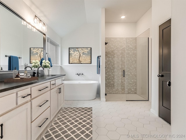 bathroom with tile patterned floors, vanity, lofted ceiling, and shower with separate bathtub