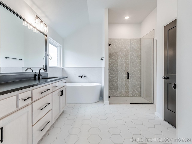 bathroom with tile patterned floors, vanity, lofted ceiling, and plus walk in shower