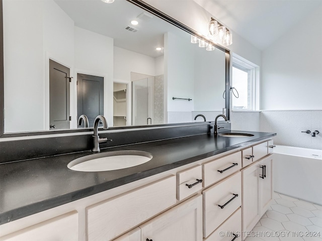 bathroom featuring tile patterned flooring, vanity, and a tub to relax in