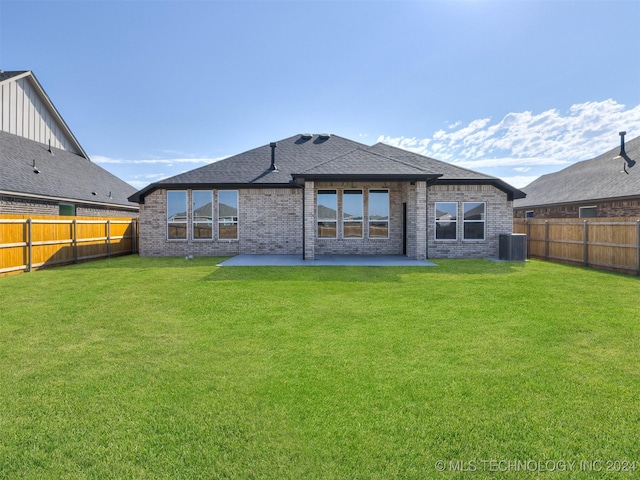 rear view of house with cooling unit, a yard, and a patio