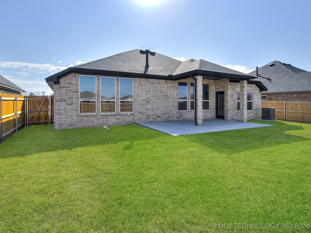 rear view of property featuring cooling unit, a yard, and a patio