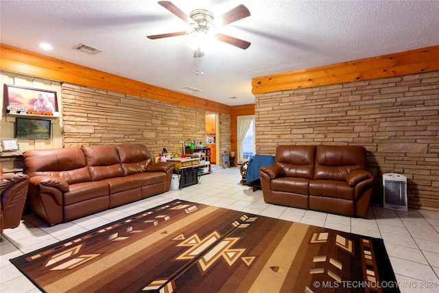 living room featuring ceiling fan, light tile patterned floors, and a textured ceiling