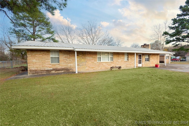 view of front of house with a carport and a front lawn