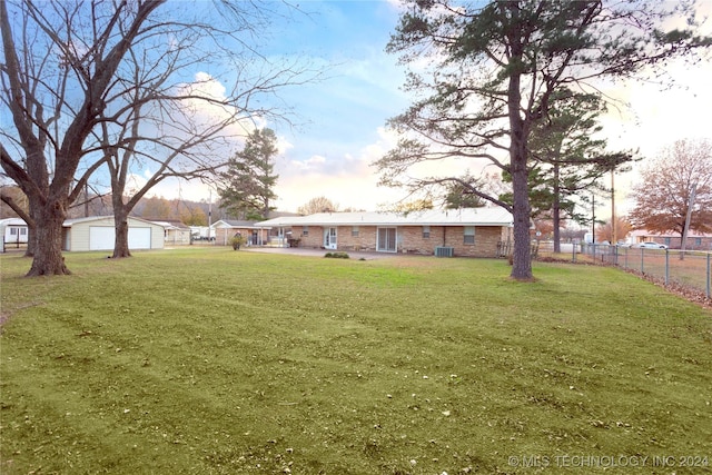 view of yard with a garage, central AC unit, and an outdoor structure