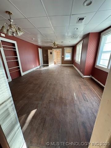 unfurnished living room with a drop ceiling and dark hardwood / wood-style floors