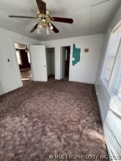 unfurnished bedroom featuring ceiling fan and dark carpet