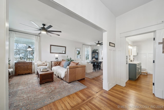 living room with light wood-type flooring and ceiling fan