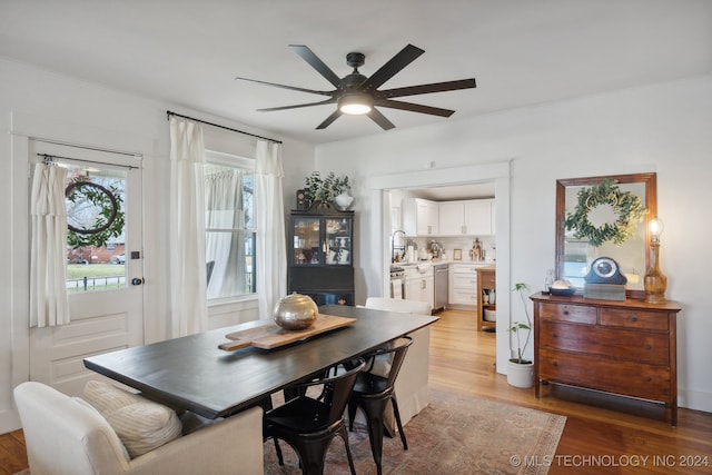 dining room with light hardwood / wood-style flooring, ceiling fan, crown molding, and sink