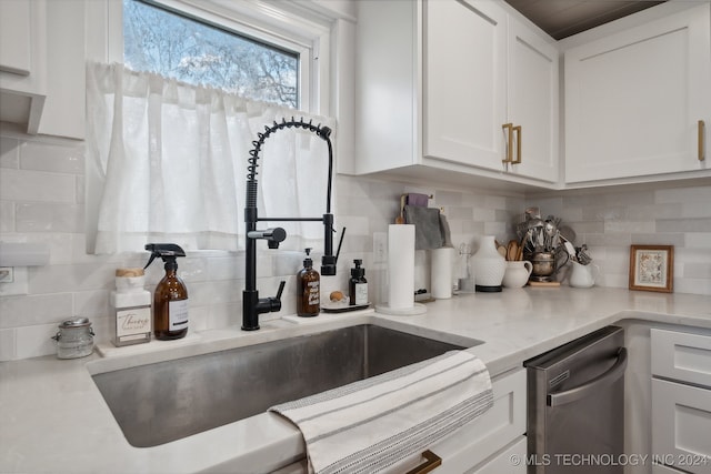 kitchen featuring sink, light stone counters, stainless steel dishwasher, backsplash, and white cabinets