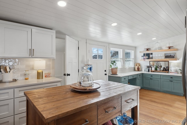 kitchen featuring tasteful backsplash, white cabinets, and light wood-type flooring