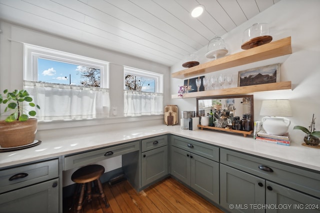 interior space with light wood-type flooring, gray cabinets, and wooden ceiling