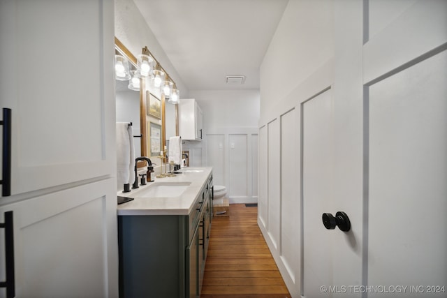 bathroom with vanity, hardwood / wood-style flooring, and toilet