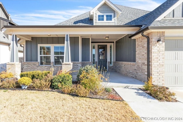 doorway to property with a garage and covered porch