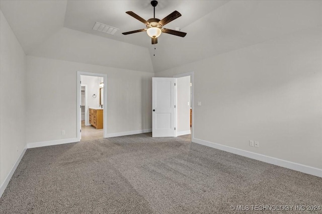 unfurnished bedroom featuring ceiling fan, light colored carpet, ensuite bathroom, and vaulted ceiling