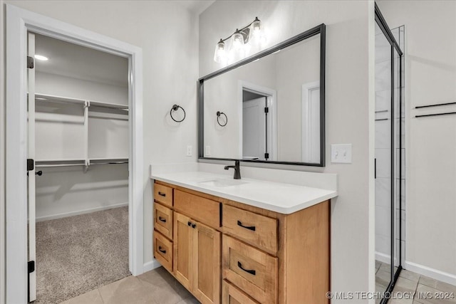 bathroom featuring tile patterned flooring, vanity, and walk in shower