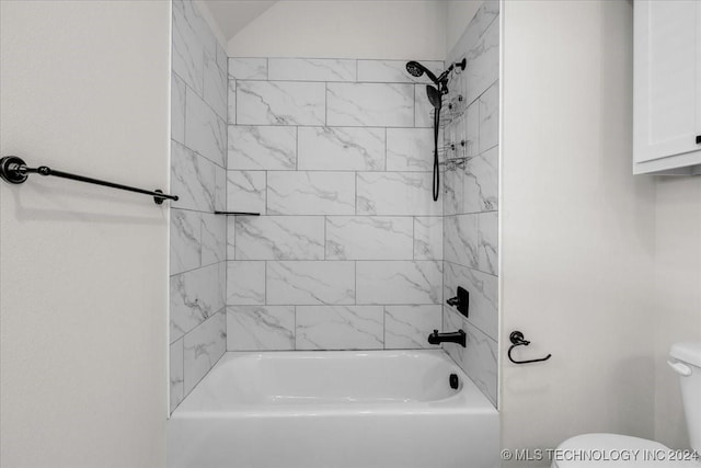 bathroom with toilet and tiled shower / bath