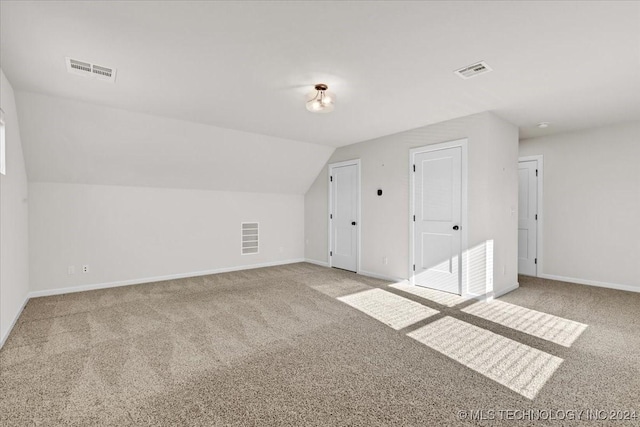 bonus room featuring light carpet and vaulted ceiling