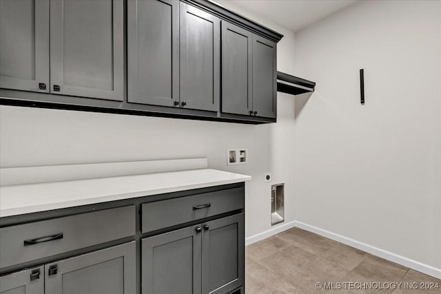 clothes washing area featuring electric dryer hookup, hookup for a washing machine, and cabinets