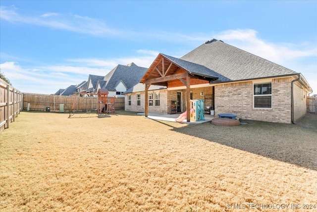 back of house featuring a patio area and a playground