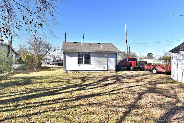 back of property featuring a yard and central AC