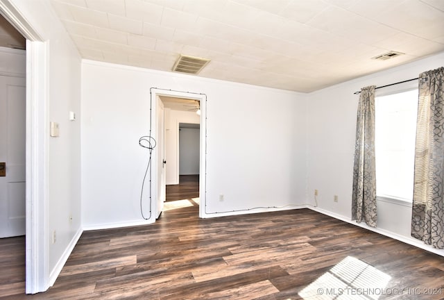 empty room featuring dark hardwood / wood-style flooring and crown molding