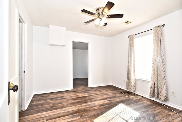 unfurnished bedroom with ceiling fan and dark wood-type flooring