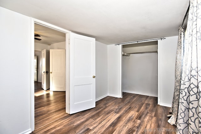 unfurnished bedroom with dark hardwood / wood-style flooring and a closet