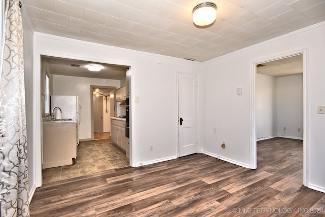 empty room featuring dark hardwood / wood-style flooring and ornamental molding