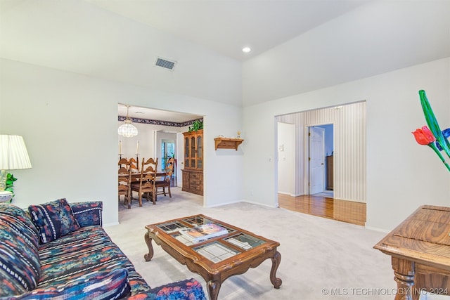 living room featuring light carpet and a chandelier