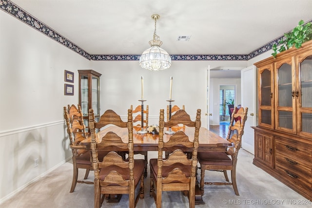 carpeted dining area featuring an inviting chandelier