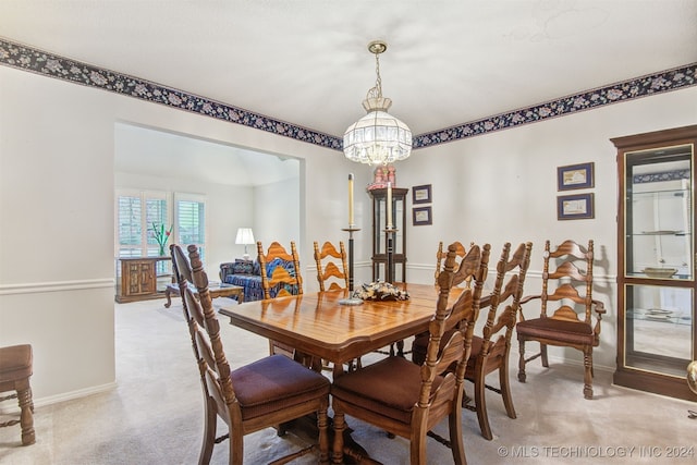 dining space with a notable chandelier and light colored carpet