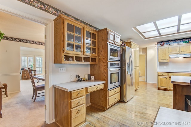 kitchen with light hardwood / wood-style flooring and appliances with stainless steel finishes