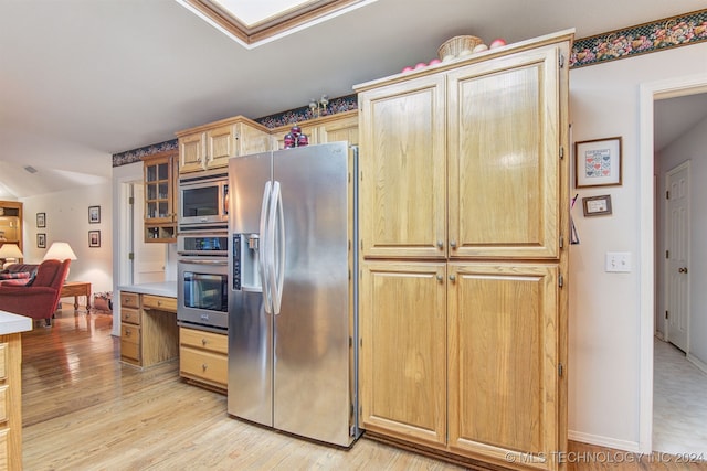 kitchen featuring appliances with stainless steel finishes and light hardwood / wood-style flooring