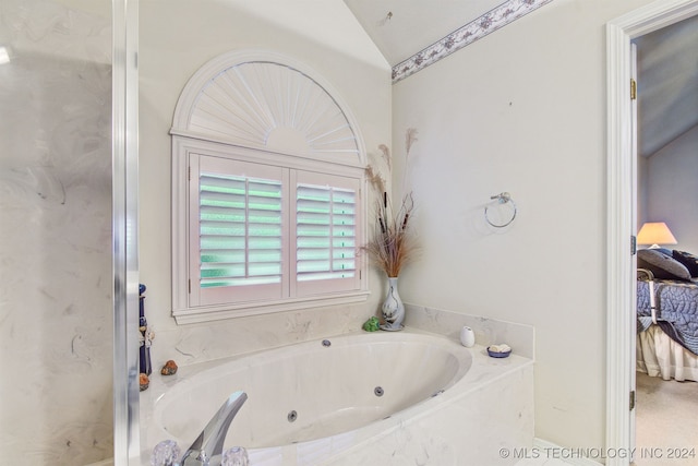 bathroom featuring tiled tub and vaulted ceiling