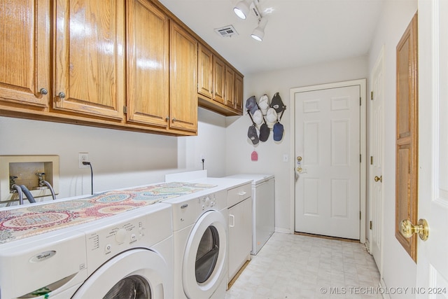 laundry area with sink, washer and dryer, cabinets, and rail lighting