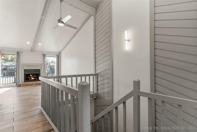 corridor featuring lofted ceiling with beams and light hardwood / wood-style flooring