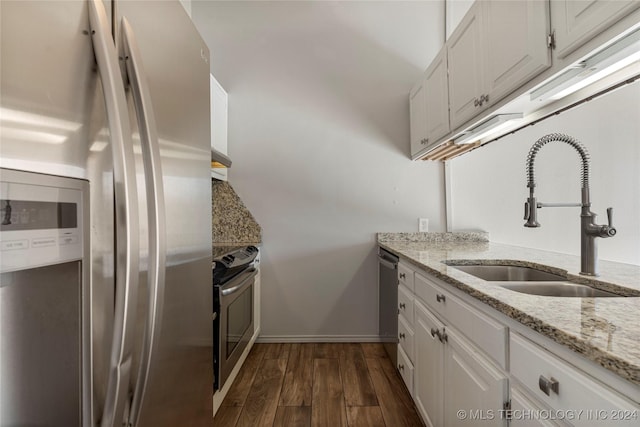 kitchen featuring appliances with stainless steel finishes, white cabinetry, dark wood-type flooring, and sink