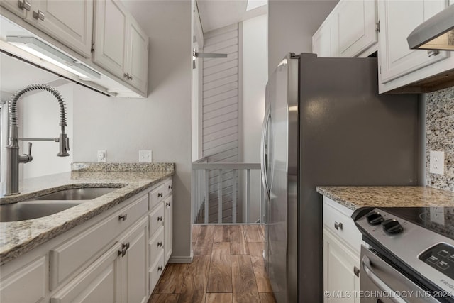 kitchen featuring sink, light stone counters, range hood, dark hardwood / wood-style floors, and white cabinets