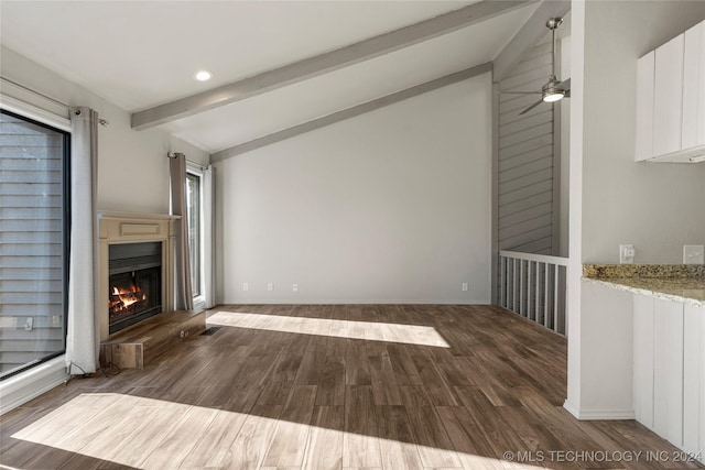 unfurnished living room featuring ceiling fan, dark hardwood / wood-style flooring, and lofted ceiling with beams