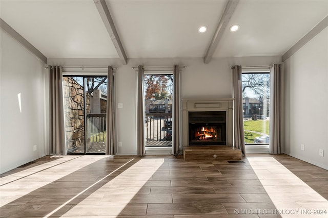 doorway to outside with wood-type flooring, a healthy amount of sunlight, and beam ceiling