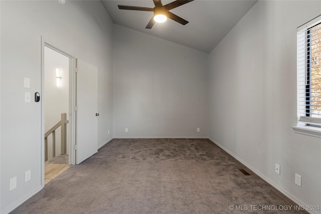 carpeted spare room featuring high vaulted ceiling and ceiling fan