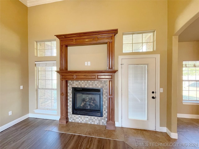 unfurnished living room featuring hardwood / wood-style flooring, a fireplace, and a high ceiling