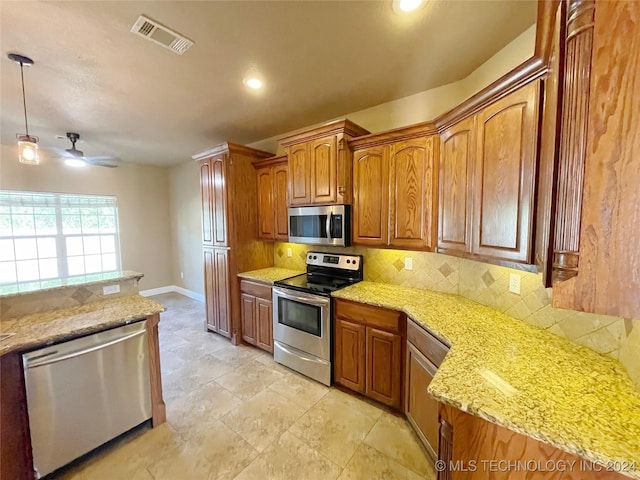 kitchen with backsplash, hanging light fixtures, ceiling fan, light stone countertops, and appliances with stainless steel finishes