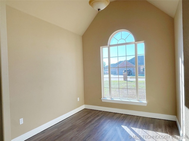 unfurnished room featuring a mountain view, dark hardwood / wood-style flooring, and lofted ceiling