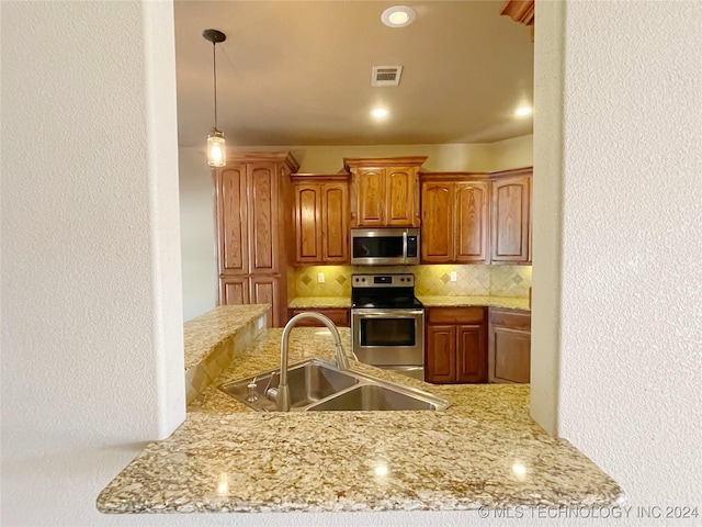 kitchen with backsplash, kitchen peninsula, sink, and appliances with stainless steel finishes