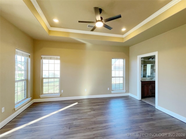 empty room with plenty of natural light, dark hardwood / wood-style flooring, and crown molding