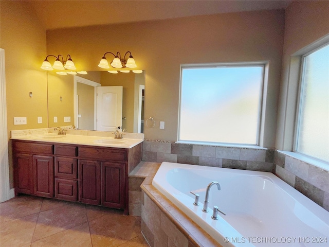 bathroom with tile patterned flooring, vanity, and tiled bath